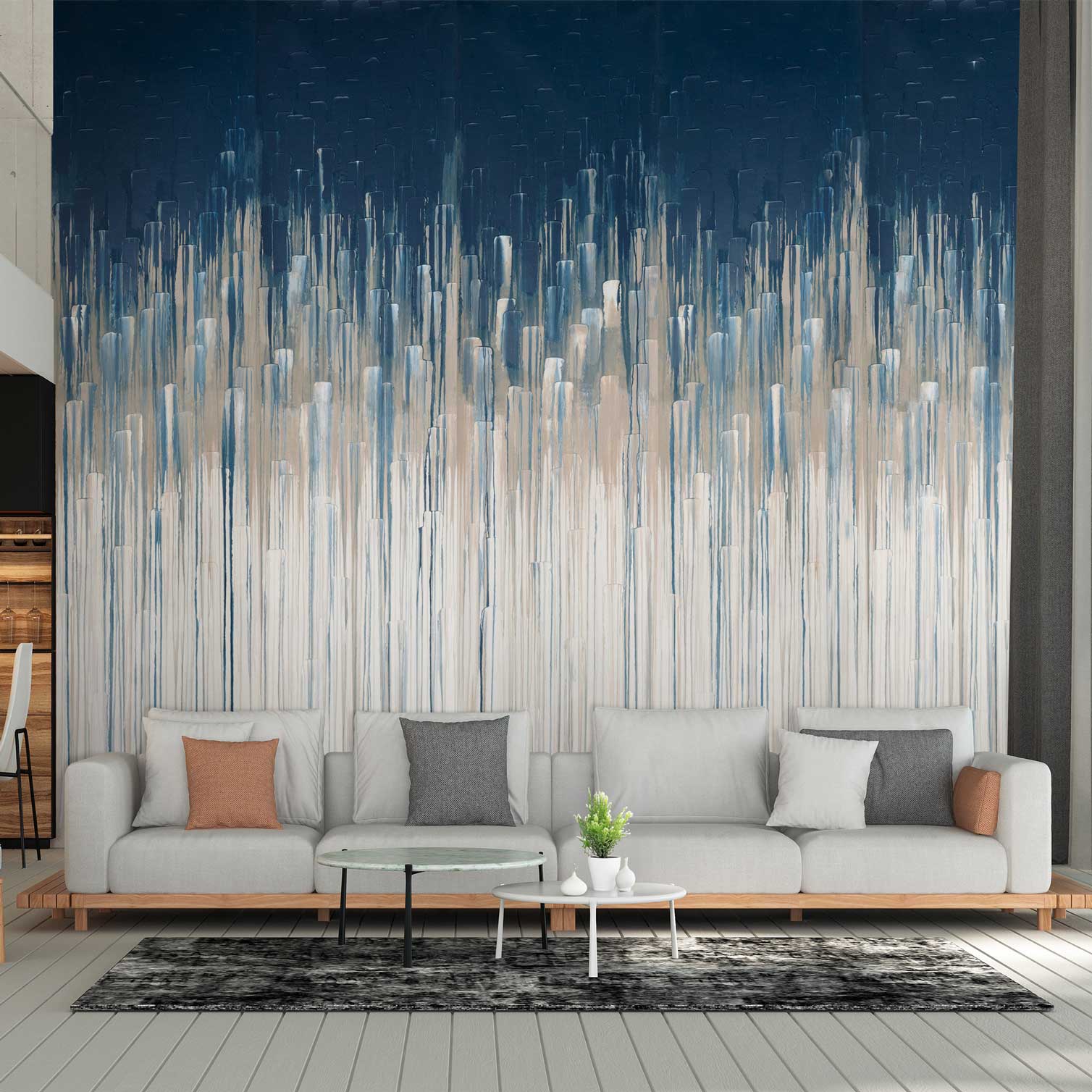 A large wall mural featuring an abstract vertical brushstroke pattern in navy blue, white, and light blue, styled behind a modern light gray sofa in a living room setting.